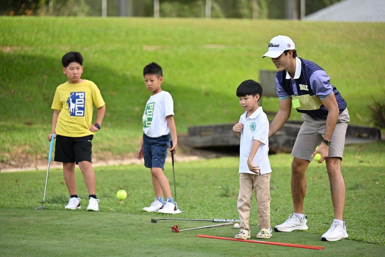 A coach running a junior lesson on the grass