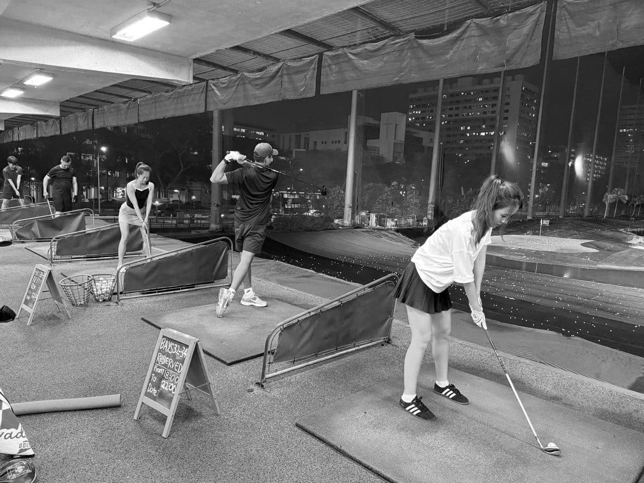 Golfers hitting balls in the range bays