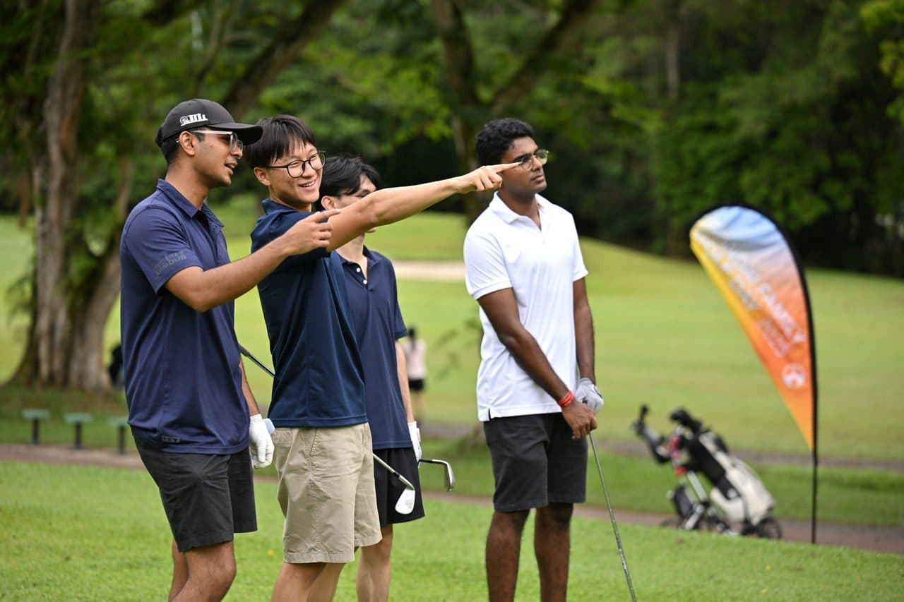Three golfers lining up a shot on the fairway